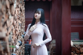 站在石壁前的粉色奥黛美女图片